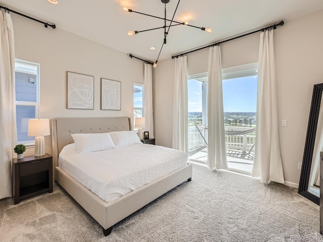 bedroom with access to outside, recessed lighting, carpet, and an inviting chandelier