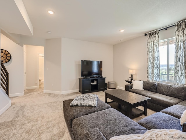 living area with baseboards, recessed lighting, and light carpet