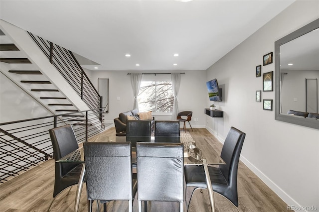 dining space featuring stairs, baseboards, wood finished floors, and recessed lighting