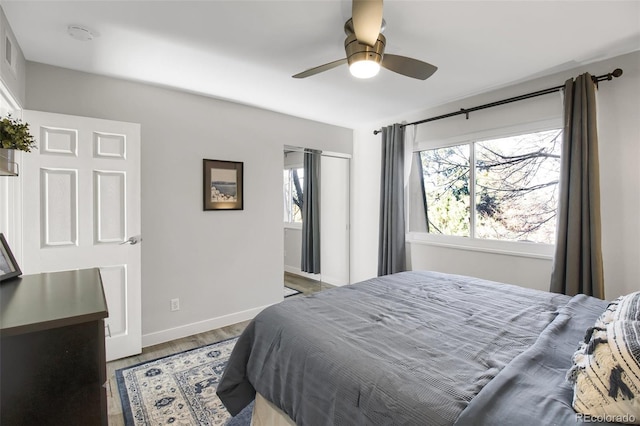 bedroom featuring wood finished floors, a ceiling fan, and baseboards