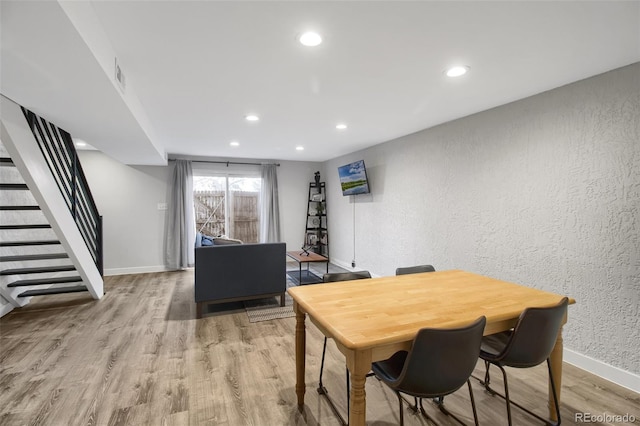 dining room with stairs, recessed lighting, baseboards, and wood finished floors