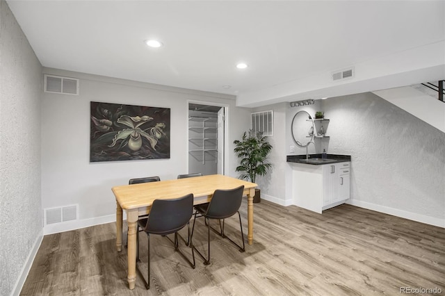 dining area featuring baseboards, visible vents, and wood finished floors