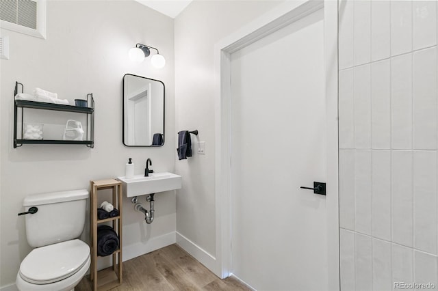 5385 W 14th Ave, Lakewood, CO 80214 - bathroom featuring wood finished floors, baseboards, toilet, and a sink