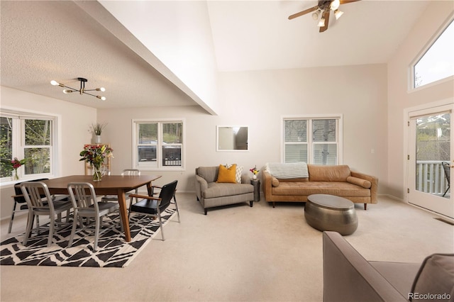 218 Highland Ter, Breckenridge, CO 80424 - carpeted living area with healthy amount of natural light, a high ceiling, ceiling fan, a chandelier, and a textured ceiling