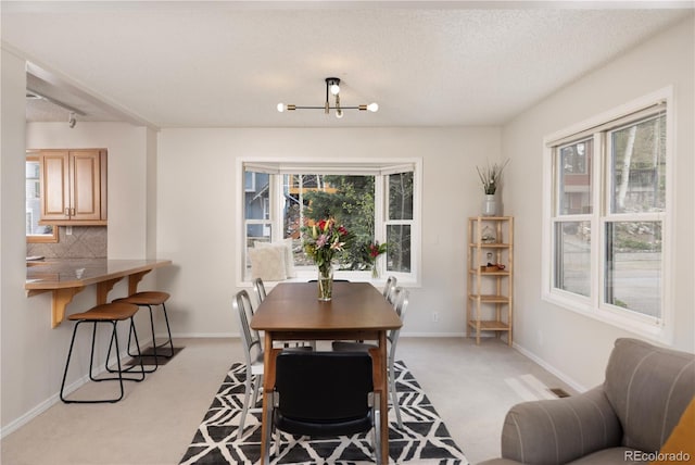 218 Highland Ter, Breckenridge, CO 80424 - dining area with light carpet, plenty of natural light, a chandelier, and a textured ceiling