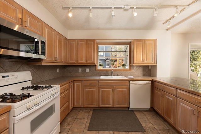 218 Highland Ter, Breckenridge, CO 80424 - kitchen featuring white appliances, backsplash, track lighting, and tile patterned floors