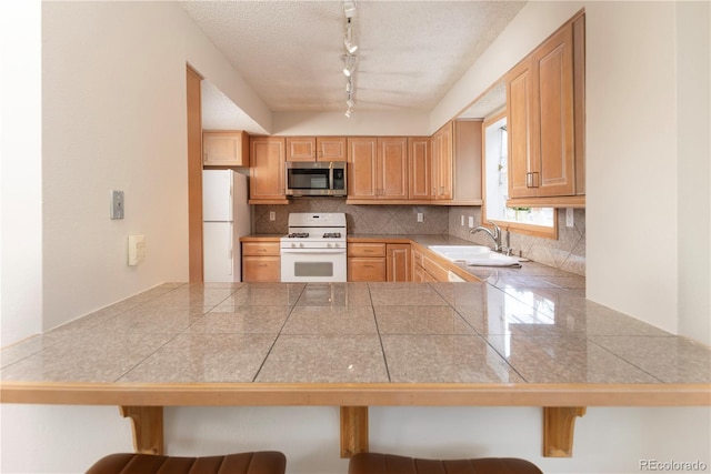 218 Highland Ter, Breckenridge, CO 80424 - kitchen with white appliances, tile counters, decorative backsplash, and a peninsula