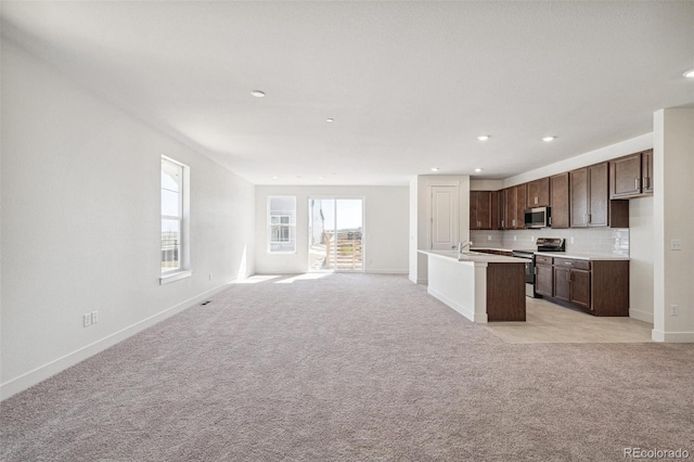 9314 Biscay St, Commerce City, CO 80022 - kitchen with stainless steel appliances, open floor plan, baseboards, and dark brown cabinets