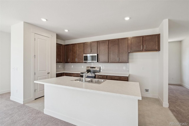 9314 Biscay St, Commerce City, CO 80022 - kitchen featuring dark brown cabinets, a sink, stainless steel appliances, light countertops, and decorative backsplash