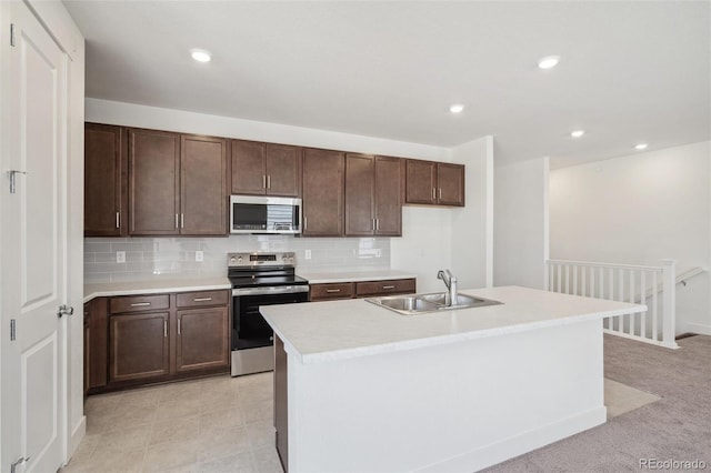 9314 Biscay St, Commerce City, CO 80022 - kitchen with stainless steel appliances, a sink, a center island with sink, light countertops, and tasteful backsplash