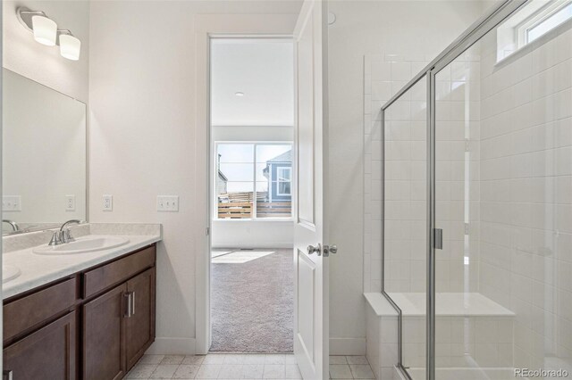 9314 Biscay St, Commerce City, CO 80022 - bathroom featuring a sink, double vanity, a stall shower, and baseboards