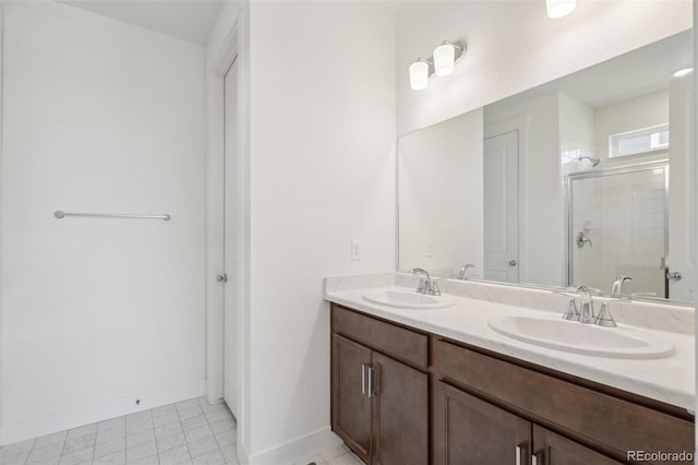 9314 Biscay St, Commerce City, CO 80022 - bathroom featuring a sink, double vanity, a stall shower, and baseboards