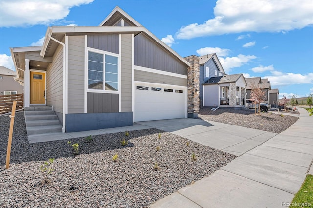 9314 Biscay St, Commerce City, CO 80022 - view of front of house with entry steps, an attached garage, stone siding, and driveway