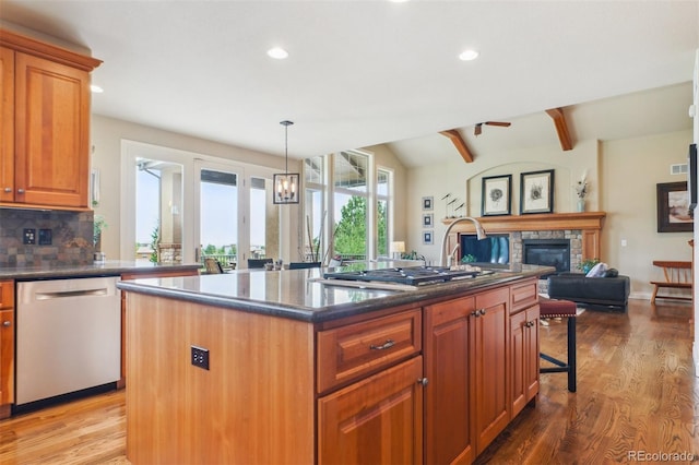 4651 Sonado Pl, Parker, CO 80134 - kitchen with appliances with stainless steel finishes, open floor plan, a stone fireplace, wood finished floors, and recessed lighting