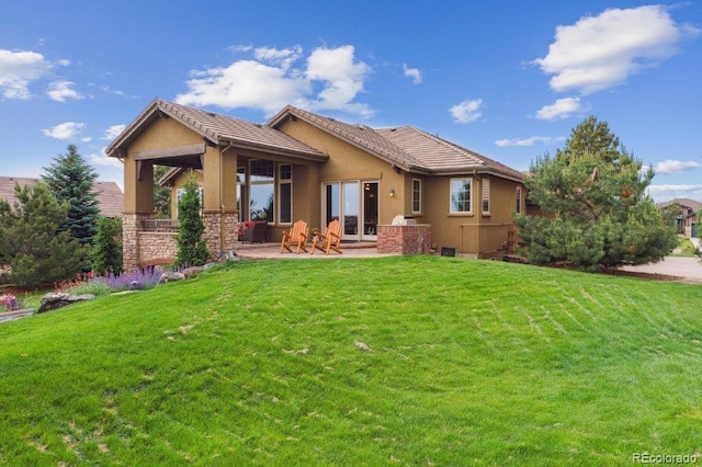4651 Sonado Pl, Parker, CO 80134 - back of property with a patio area, a lawn, stucco siding, and a tiled roof