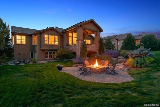 4651 Sonado Pl, Parker, CO 80134 - back of property at dusk featuring a fire pit, a patio, a lawn, and stucco siding