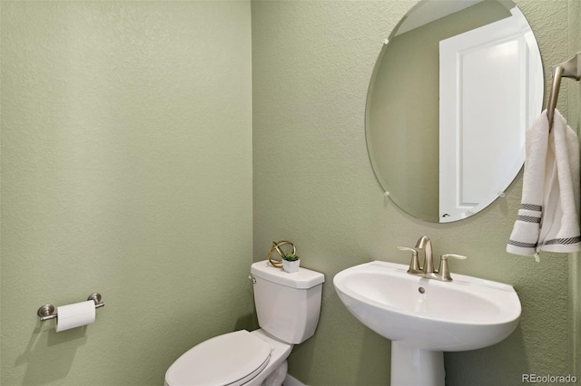 half bathroom featuring toilet and a sink