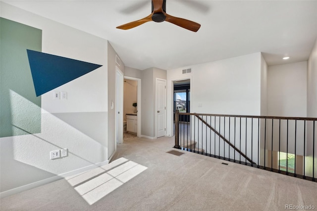 unfurnished room featuring carpet flooring, a ceiling fan, and baseboards
