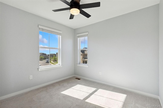 spare room with light carpet, baseboards, and ceiling fan