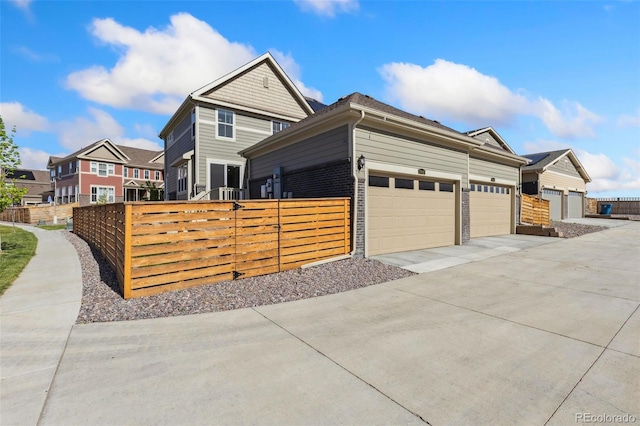 view of front of home with fence, concrete driveway, and an attached garage