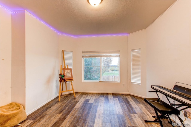 unfurnished room featuring a textured ceiling and dark hardwood / wood-style flooring