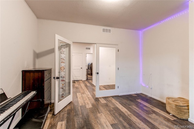 interior space with french doors, dark hardwood / wood-style floors, and a textured ceiling