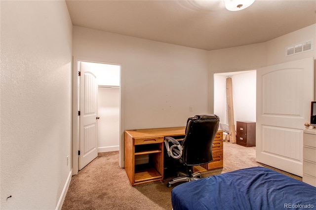 bedroom with carpet and a walk in closet