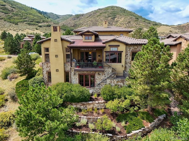 rear view of property featuring a balcony and a mountain view