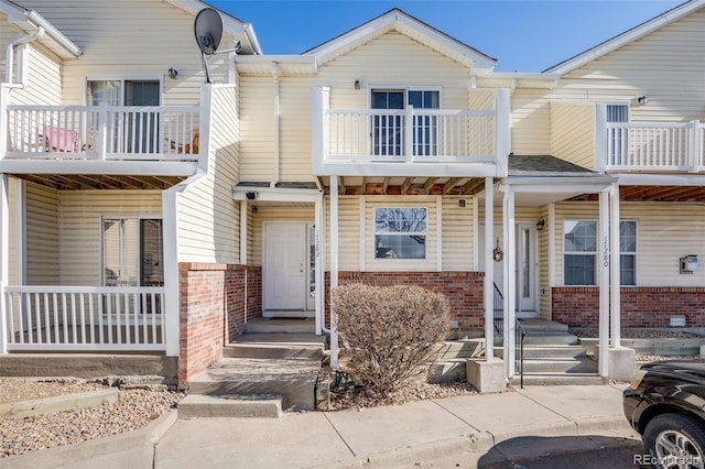 multi unit property with brick siding and a balcony