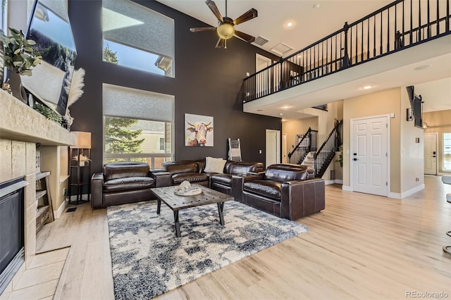7378 Geode Ct, Castle Rock, CO 80108 - living area featuring a fireplace, wood finished floors, a high ceiling, plenty of natural light, and ceiling fan