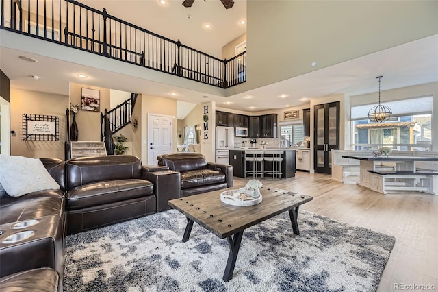 7378 Geode Ct, Castle Rock, CO 80108 - living area with stairway, light wood-style flooring, ceiling fan, a towering ceiling, and recessed lighting