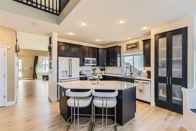 7378 Geode Ct, Castle Rock, CO 80108 - kitchen with high quality appliances, a sink, light countertops, a center island, and light wood-style floors