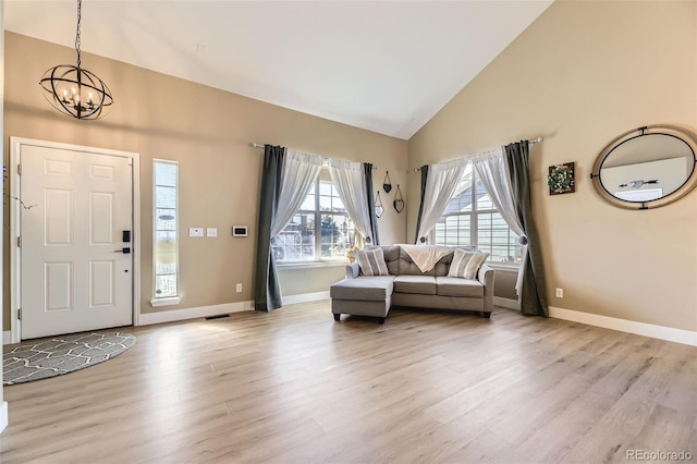7378 Geode Ct, Castle Rock, CO 80108 - foyer entrance featuring high vaulted ceiling, a chandelier, light wood finished floors, and baseboards