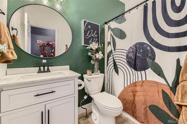 7378 Geode Ct, Castle Rock, CO 80108 - full bath with a textured wall, wood finished floors, toilet, vanity, and curtained shower