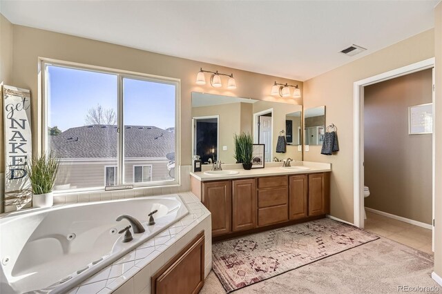 7378 Geode Ct, Castle Rock, CO 80108 - bathroom with a jetted tub, toilet, double vanity, baseboards, and tile patterned floors