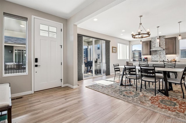 dining area featuring a notable chandelier and light wood-type flooring