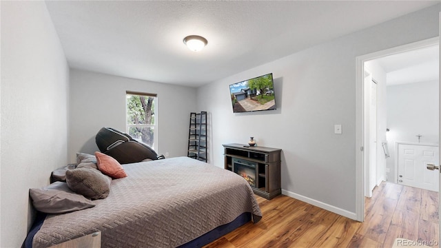 bedroom featuring light wood-style flooring and baseboards