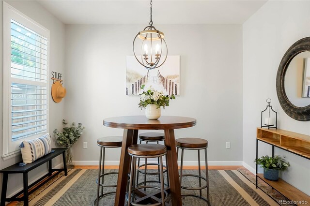 8427 E 35th Ave, Denver, CO 80238 - dining room featuring wood finished floors, baseboards, and a chandelier