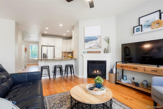 8427 E 35th Ave, Denver, CO 80238 - living room featuring light wood-style floors, a ceiling fan, recessed lighting, a glass covered fireplace, and baseboards
