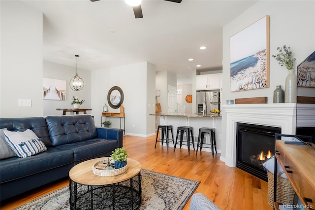 8427 E 35th Ave, Denver, CO 80238 - living room featuring ceiling fan, light wood-type flooring, recessed lighting, a glass covered fireplace, and baseboards