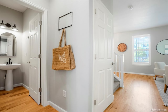 8427 E 35th Ave, Denver, CO 80238 - corridor with light wood-type flooring, baseboards, a sink, and stairway