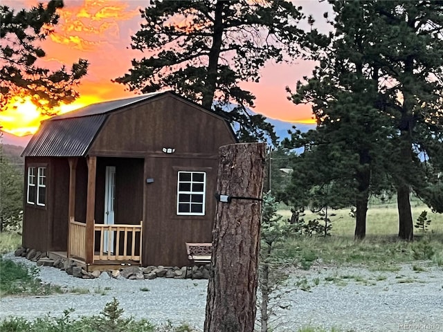 property exterior at dusk featuring an outdoor structure