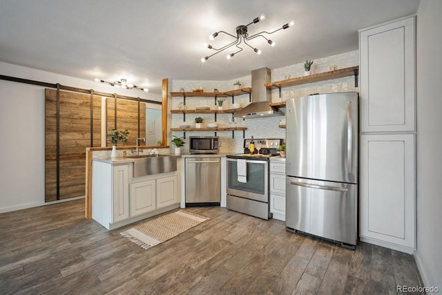 1625 Larimer St Unit 3004, Denver, CO 80202 - kitchen with stainless steel appliances, wall chimney range hood, a barn door, open shelves, and wood finished floors