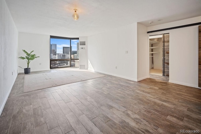 1625 Larimer St Unit 3004, Denver, CO 80202 - unfurnished living room with wood finished floors, baseboards, and expansive windows