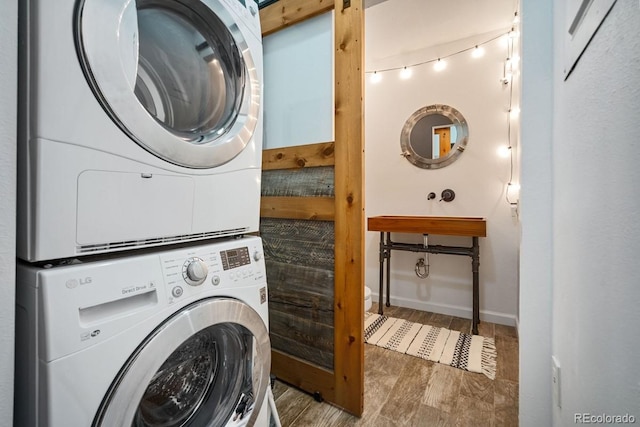 1625 Larimer St Unit 3004, Denver, CO 80202 - laundry area featuring stacked washer / drying machine, wood finished floors, and baseboards