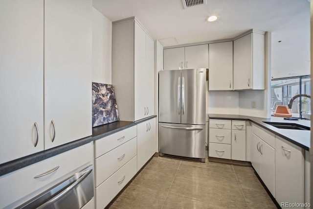 1625 Larimer St Unit 3004, Denver, CO 80202 - kitchen with freestanding refrigerator, a sink, dark countertops, a warming drawer, and white cabinets