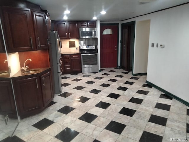 kitchen with a sink, tasteful backsplash, recessed lighting, stainless steel appliances, and baseboards