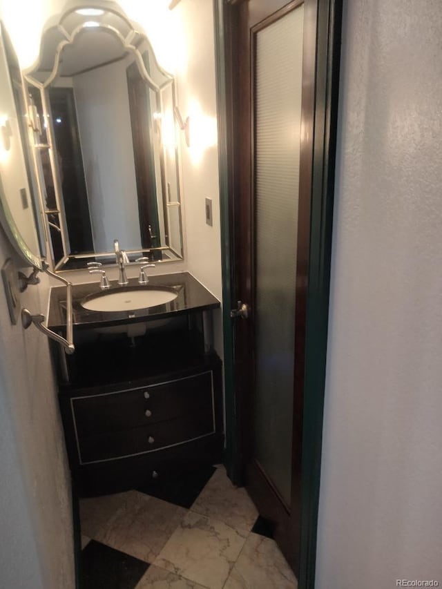 bathroom with marble finish floor and vanity