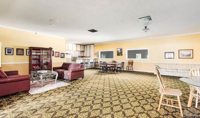 living room with visible vents, baseboards, and ornamental molding