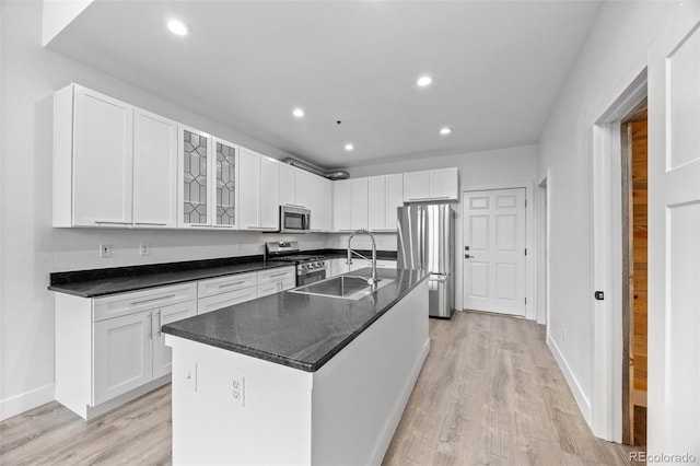 7700 E 29th Ave Unit 102, Denver, CO 80238 - kitchen with appliances with stainless steel finishes, a sink, light wood-style flooring, recessed lighting, and white cabinets